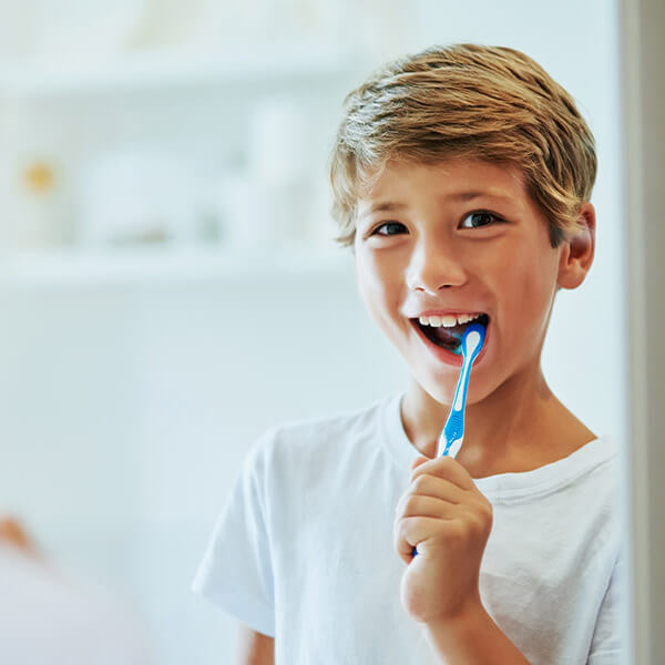 A young boy with brushing his teeth