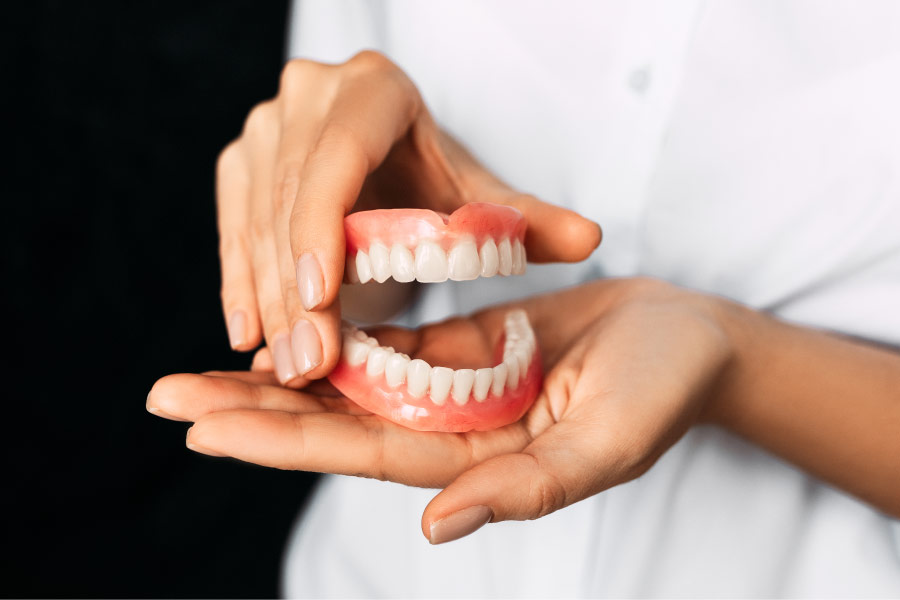 set of dentures held in two hands